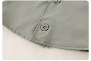 Détails de l'ourlet arrondi et des boutons sur une veste décontractée vert clair