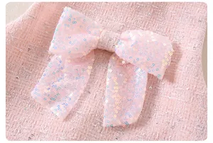 Detalle del vestido de tweed rosa con hilos plateados brillantes y un lazo grande de lentejuelas