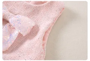 Detalle del cuello de vestido de tweed rosa con un lazo grande de lentejuelas y brillo