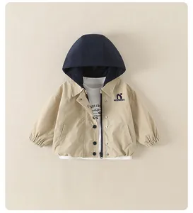 Dettaglio della giacca con cappuccio beige e blu da bambino con cerniera e t-shirt