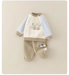 Détail de l'ensemble bébé en coton avec manches raglan bleues et broderie chiot