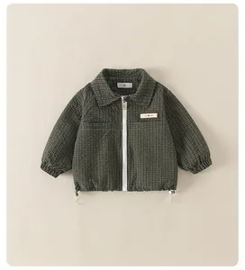 Detail of green plaid kids jacket showing bubble texture fabric and CHIC MORO label