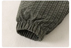 Detail of green plaid kids jacket showing elastic cuffs and premium woven texture