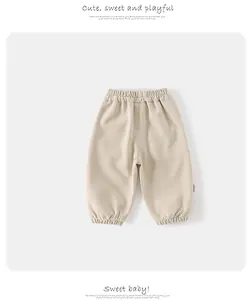 Détail d'un jogging beige pour enfant avec taille élastique et chevilles resserrées