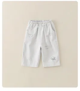 Dettaglio dei pantaloni in cotone per neonati con stampe di cuccioli ed elefanti