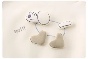 Détail du pull en coton pour bébé avec écusson chien 3D et broderie bleue élégante