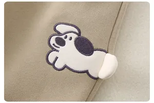 Détail de broderie chiot avec queue pompon 3D sur un ensemble en coton kaki pour enfant