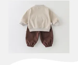 Vue détaillée à plat du sweat beige pour bébé et de l'ensemble de pantalon marron