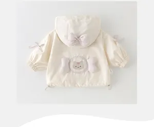 Detail der Babymädchen-Kapuzenjacke mit rosa Karoschleifen und süßer Katzen-Stickerei
