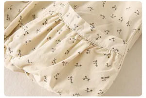 Detail of floral baby girl jacket featuring ruffled pocket design and cotton fabric