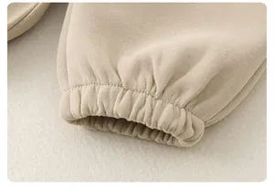 Détail des poignets élastiques côtelés sur l'ensemble en coton beige pour garçon