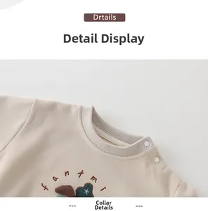 Détail d'un sweat pour bébé abricot avec col côtelé, boutons-pression et broderie champignon