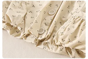 Close-up of baby floral cotton jacket featuring rustic brown prints and cream buttons
