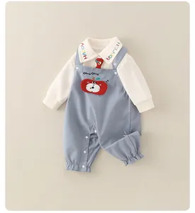 Détail de chemise bébé blanche avec broderie HAPPY colorée et patch en forme de pomme