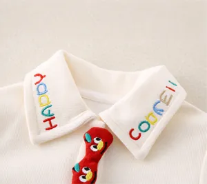 Close-up of off-white ribbed baby top featuring colorful embroidery and cute cartoon patch