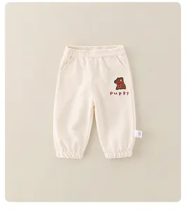 Detail der beigen Baby-Jogginghose aus Baumwolle mit Gummizug und Welpen-Aufdruck