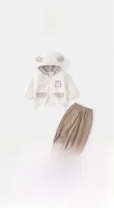 Detail of cream hooded jacket with animal ears and brown joggers infant set