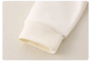 Détail des poignets en maille côtelée sur haut crème à manches longues pour garçon