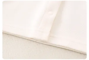 Détail des coutures du tissu côtelé et du bouton-pression pour vêtement de bébé