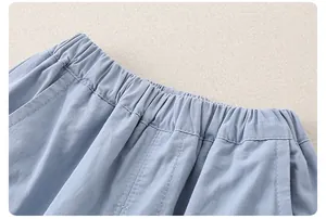 Dettaglio dei pantaloni in cotone celeste con elastico in vita e cuciture rifinite