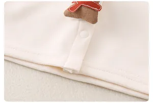Detail der Baby-Baumwollkleidung mit Lebkuchenmann-Stickerei und Druckknopfverschluss