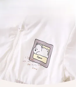 Close-up of white baby jacket with cartoon polar bear print and smooth fabric detail