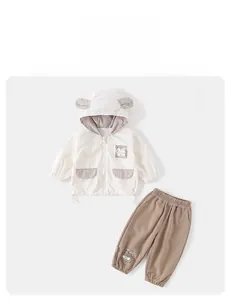 Detail of baby boys spring outfit with animal ear hood and decorative patch pockets