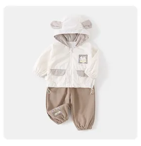 Detail view of baby hooded jacket with bear ears and matching khaki trousers