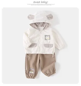 Detail view of baby hooded zip jacket with cute ears and matching khaki trousers