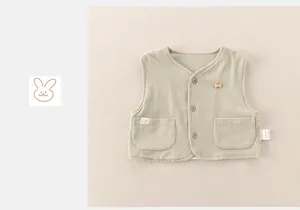 Dettaglio gilet neonato verde salvia con bottone a forma di osso e taschini