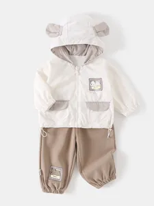 Cute baby boy two-piece set featuring cream hooded bear jacket and brown cotton pants