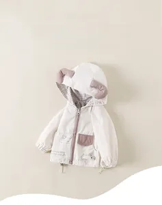 Détail du coupe-vent à capuche avec imprimé chiot mignon et accents d'oreilles 3D
