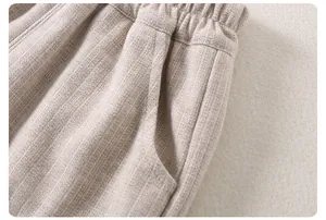 Detail of baby oatmeal textured cotton pants with elastic waistband and side pockets