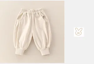 Detail of baby boys beige jogger pants with elastic waist and cute cartoon print