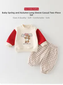 Detail of baby boys cotton set featuring bear embroidery and plaid jogger pants
