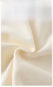 Macro detail of soft cream knitted cotton fabric with premium Grade A texture for baby clothing