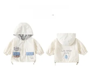 Detail view of cream white toddler jacket with blue pockets and cute bear motif