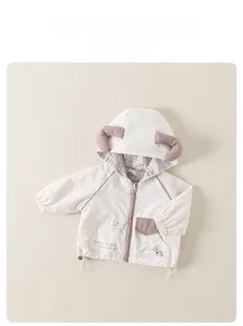 Détail d'une veste à capuche pour bébé avec imprimés animaux et poches violettes