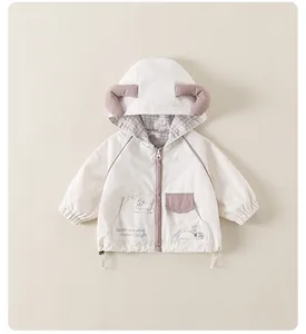 Détail du coupe-vent crème pour enfants avec motif chien et doublure à carreaux doux