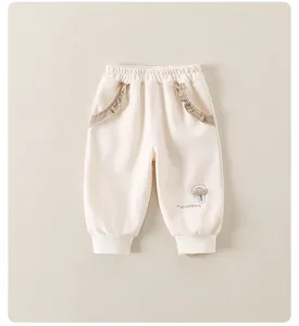 Dettaglio dei pantaloni per bambina con tasche a volant e ricamo a fungo grazioso