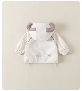 Détail de la veste enfant avec capuche à cornes mauves et broderie de chien mignon