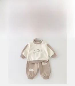 Flat lay of baby boy cotton two-piece set with cartoon animal print and patch details