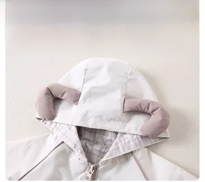 Détail d'une veste à capuche pour enfant avec cornes 3D et doublure à carreaux