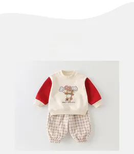 Detailed flat lay of boys' cotton sweatshirt with bear graphic and plaid pants