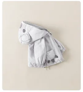 Close-up of boys light grey hooded jacket featuring cute cartoon ears and plaid lining