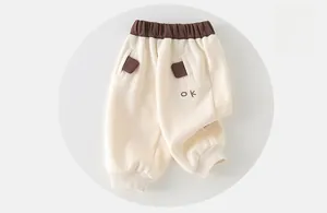 Vue détaillée du jogging pour tout-petit blanc crème avec taille marron et broderie OK