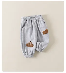 Detail of gray kids joggers featuring a cute dinosaur patch and LULU embroidery on the leg