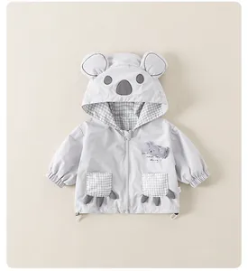 Detail of baby hooded jacket featuring cute koala ears and plaid pockets with paw accents