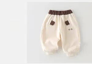 Détail du jogging crème pour enfant avec taille élastique marron et broderie OK