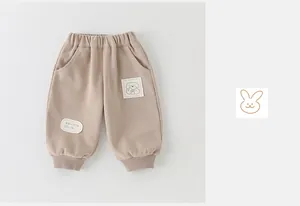 Detail of khaki cotton baby jogger pants with cute puppy patches and ribbed elastic waist
